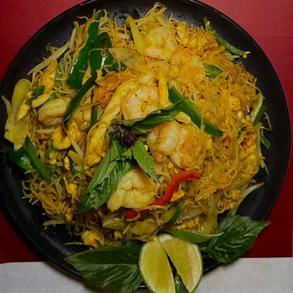House of Chou's Chinese noodles with shrimp, green peppers, cashews, and lime wedges.