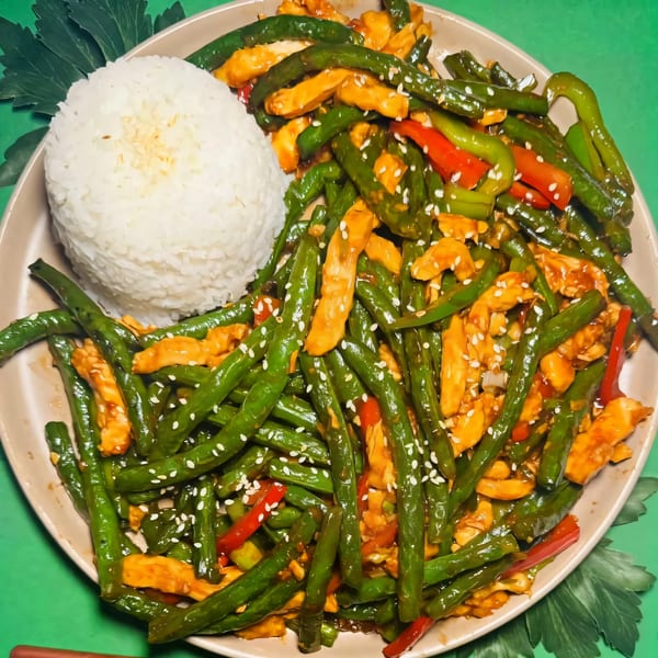 House of Chou's chicken and green bean stir-fry with white rice, garnished with sesame seeds.